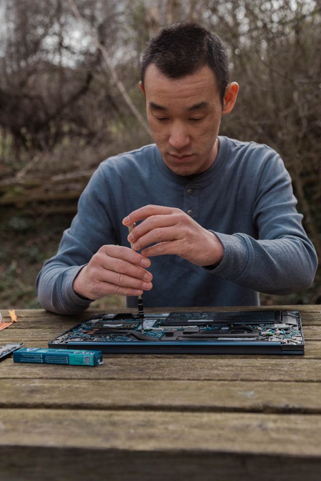 Nathan Chan - Sifu Geek - working on a laptop on a park bench