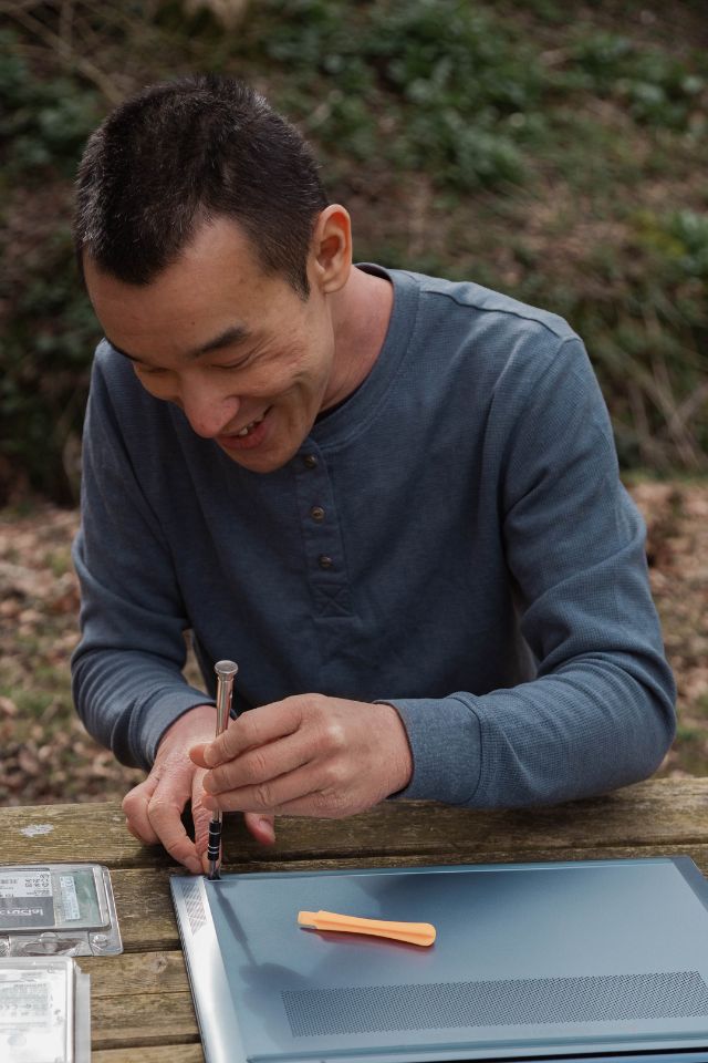 Nathan Chan - Sifu Geek - working on a laptop on a park bench